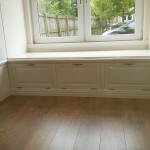 A window seat with cupboards and shelves