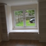 A window seat with cupboards and shelves